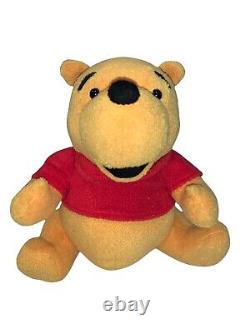 Disney Store a rejoint Winnie l'ourson en peluche de 12 pouces portant un t-shirt rouge.